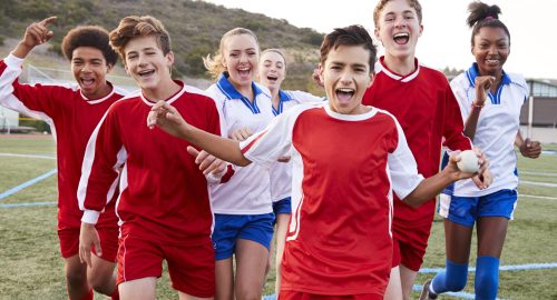Portrait Of Male And Female High School Soccer Teams Celebrating